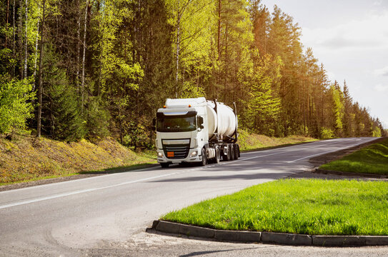 Fototapeta Tank truck transports chemical product, liquefied gas, dangerous cargo. Beautiful summer sunny nature. Copy space for text