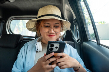 Young Asian woman takes an online taxi to her hotel while on holiday in Surakarta, Indonesia