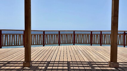 A beautiful wooden deck with a stunning view of the sparkling ocean, perfect for relaxation and...