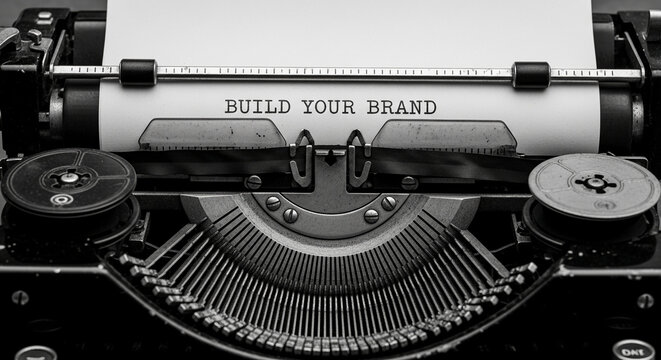 Close-up of vintage typewriter with paper showing "Build Your Brand" text, showcasing retro style and branding concept, ideal for marketing or business themes - Powered by Adobe