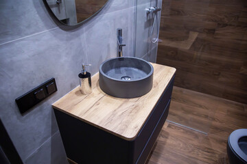 Modern grey stone sink in wall hung vanity in bathroom. New stylish bathroom renovation. Copy space...