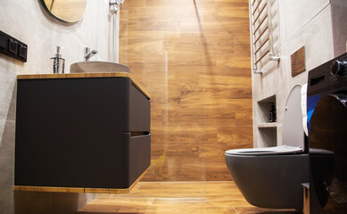 Contemporary bathroom with wood effect tiles, grey wall hung cabinet and toilet. Copy space for...