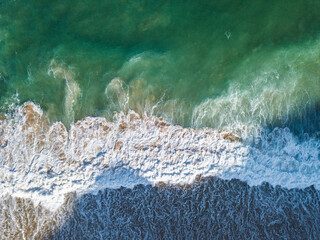Aerial View of Ocean Waves Hitting Sandy Shore. Aerial drone view. natural background