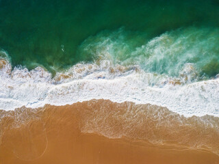 Aerial View of Ocean Waves Hitting Sandy Shore. Aerial drone view. natural background