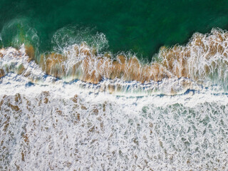 Aerial View of Ocean Waves Hitting Sandy Shore. Aerial drone view. natural background