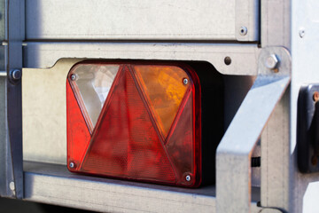Electric turn signal, brake light and side lights on galvanized trailer, close-up