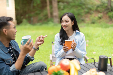 Engaging Conversation. Young couple sharing coffee and laughter outdoors.