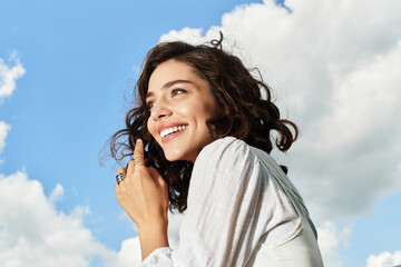 Joyful summer moments under the bright blue sky with a lovely young woman