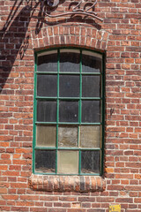 Altes Fenster mit Backsteinwand an einem Hafenschuppen, Deutschland