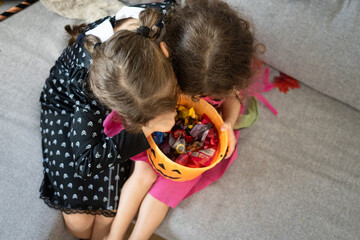 Two young sisters dressed in Halloween costumes