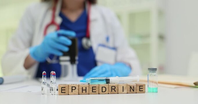 Blocks show word Ephedrine put near test tubes and vials with syringe in laboratory. Doctor puts stamp while studying stimulant chemical properties