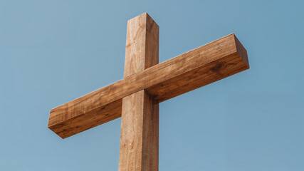 Large wooden cross standing tall against clear blue sky