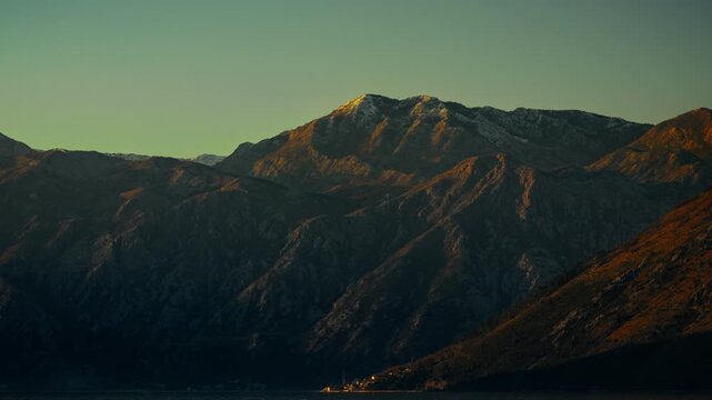 A timelapse of night turning into morning, illuminating the peaks of high mountains the sun rises in the mountains and night fades into dawn