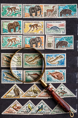 Postage stamps. Collection of stamps and magnifying glass. Collection of world stamps in a stack...