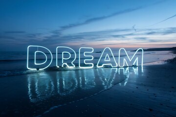 Dream word illuminated by neon lights on a beach at dusk with reflections in the water
