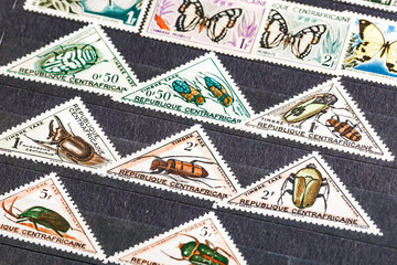 Postage stamps. Collection of stamps and magnifying glass. Collection of world stamps in a stack demonstrates the theme of flora and fauna. Postage stamps of different countries and times