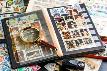 Postage stamps. Collection of stamps and magnifying glass. Collection of world stamps in a stack...