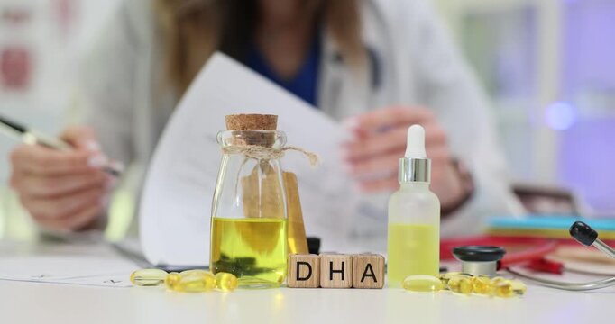 DHA written on cubes stands by supplements and oil in transparent jar on table. Word connects to omega-3 used in brain development and memory support