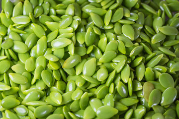 Close-up image of numerous glossy green seeds of Leucaena leucocephala, arranged naturally. Ideal for botanical, agricultural, and ecological design themes.