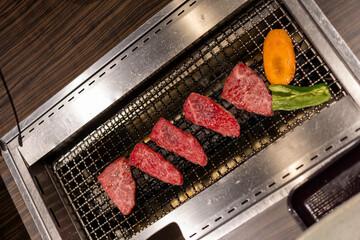 cooking raw beef meat on grill with fire and heat, metal wire grill equipment, high quality wagyu from Japan