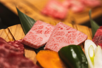 raw beef steak, A5 Wagyu on wooden plate, Japanese beef for yakiniku, high quality meat from Japan, BBQ meal in All-you-can-eat restaurant