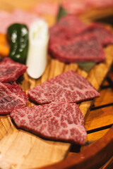 raw beef steak, A5 Wagyu on wooden plate, Japanese beef for yakiniku, high quality meat from Japan, BBQ meal in All-you-can-eat restaurant