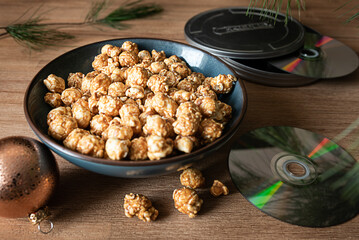 Close-up of popcorn on a coffee table, with a CD for movie night.