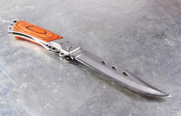 Folding pocket knife with a wooden handle, on an isolated background.