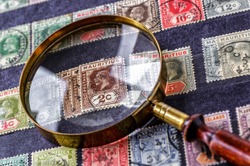 Ukraine, Kiyiv - February 3, 2024.Postage stamps from Mauritius.Collection  vintageof stamps and magnifying glass.Postage stamps from different countries and times