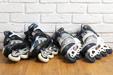 Roller skates on wooden table near white brick wall