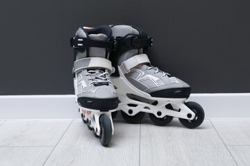 Pair of roller skates on floor near black wall