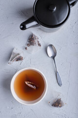 Top view of a cup of tea and pot on white background with spoon