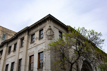 The corner of an old gray house against the sky