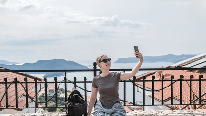 Woman enjoys solo travel, retreat and mindfulness sea, mountain, coast, marina; exploring slow adventure, freedom, calm, awareness, soft experience, relaxation, selfcare, youth lifestyle.