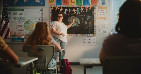 Female Teacher Conducting Lecture on Ecology to Primary School Children in Modern Classroom. Group...