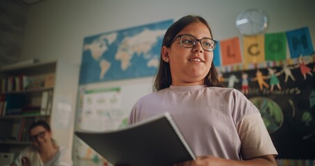 Renewable Energy Lesson: Elementary School Girl with Notebook Speaking, Giving Presentation on...