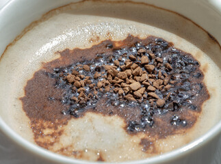 A layer of cappuccino with frothed milk and a topping of instant Arabica or Robusta coffee...