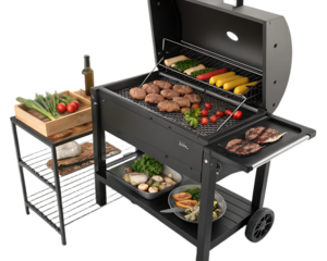 A black charcoal grill with food on the grates and a side table with vegetables and olive oil
