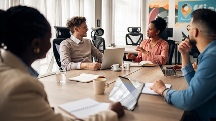 Business Professionals Engaged in Team Discussion Around a Table in Modern Office