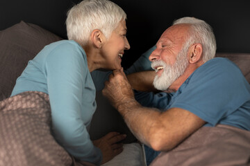 Affectionate senior couple in bed. Age doesn&rsquo;t matter in love - concept