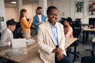 Confident Businesswoman Smiling in Modern Office With Diverse Team Members