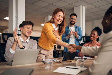 Team Members Celebrating Success at a Meeting Through Handshakes and Applause