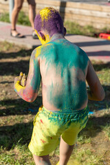 Child covered in colorful powder during holi festival celebration