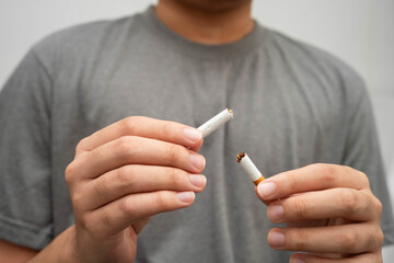 Quit smoking, Asian teenage man breaking destroy cigarette in hand.