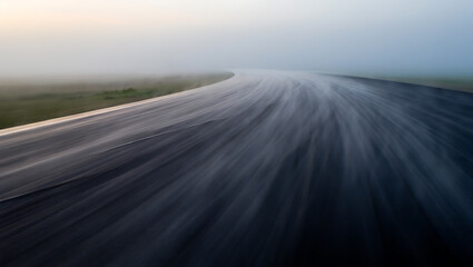 Winding asphalt road in misty landscape image