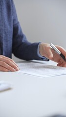 Businessman reviewing contract details, professional hands examining document before signing...