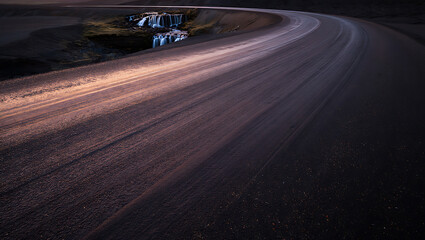 Winding Road Leading to Cascading Waterfalls at Dusk gravel dirt