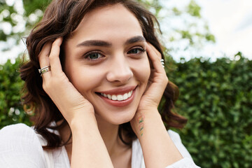 Smiling young woman enjoying a sunny summer day in a lush green park