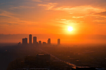 Sunlit Urban Skyline with Warm Orange and Yellow Hues at Sunrise.