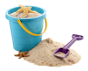 A blue beach bucket filled with sand and a starfish next to a purple shovel on a sand pile
